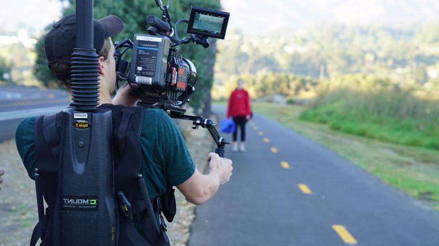 student filming person on road